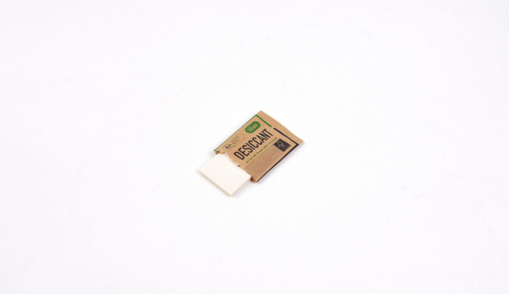 Dust-free fiber desiccant pad shown inside a kraft sachet for powder packaging