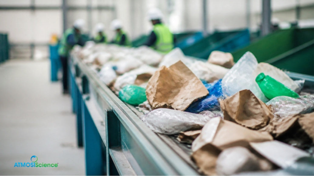 Mixed packaging waste moving along a recycling sorting conveyor